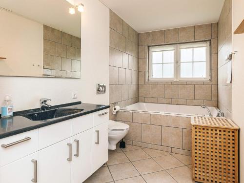 a bathroom with a tub and a toilet and a sink at 8 person holiday home in Bogense-By Traum in Bogense