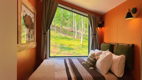 a bedroom with a bed with a large window at Bison Farm - Cabin "Loma" in Culpeper