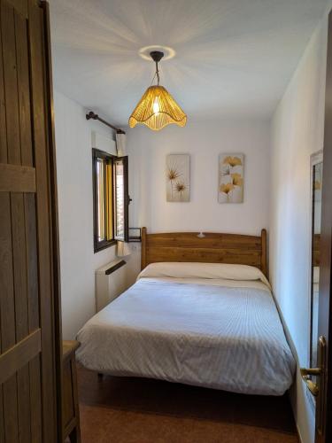 a bedroom with a bed and a light fixture at At - Anita in La Alberca