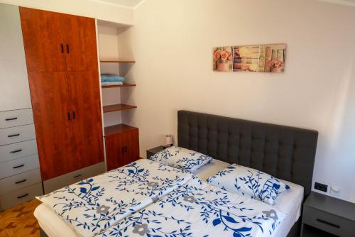 a bedroom with a bed with a blue and white bedspread at Apartman Ika Umag in Umag