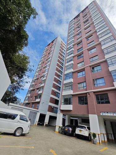 a large apartment building with cars parked in a parking lot at Leo residences 1 in Eldoret