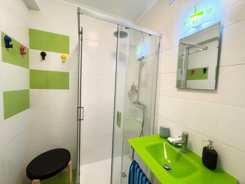 a bathroom with a green sink and a shower at Horta Joy! in Horta