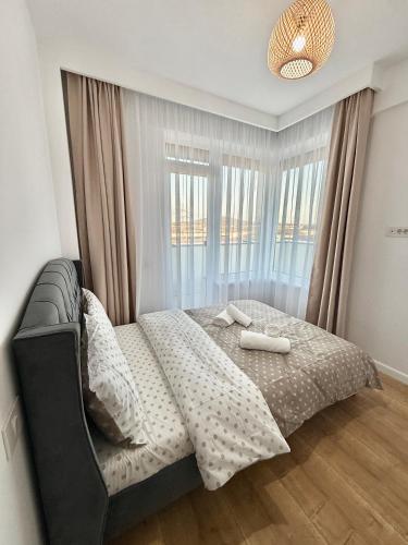 a bedroom with a bed with two towels on it at Elegance Apartments in Baile Felix