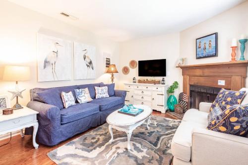 a living room with a blue couch and a tv at Herons' Haven in Charleston