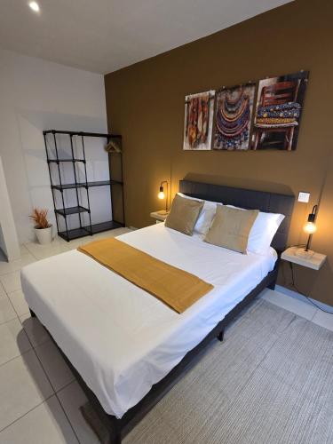 a bedroom with a large bed with white sheets and pillows at Tina Bay in Mindelo
