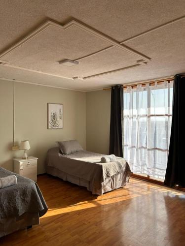 a bedroom with a bed and a window at Hotel Boutique Casa Piedra in Tocopilla