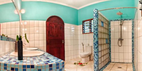 a bathroom with a toilet and a red door at The Garden Suite in Mtwapa