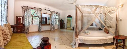 a bedroom with a bed with a canopy in a room at Penety Villa in Shanzu
