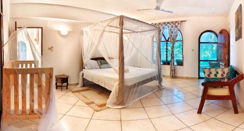 a bedroom with a bed with a canopy at Tranquil Middle Apartment in Mtwapa