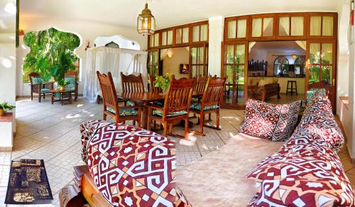 a living room with a couch and a table and chairs at The Garden Suite in Mtwapa