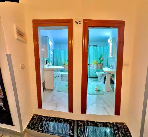 a bathroom with two sinks and two mirrors at Grandpas House in Gjirokastër