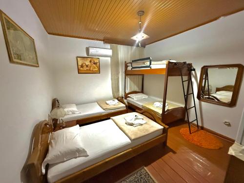 a room with two bunk beds and a mirror at Grandpas House in Gjirokastër