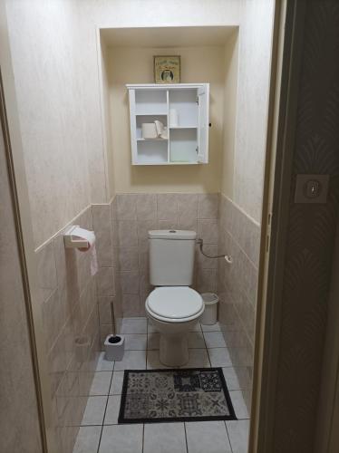 a small bathroom with a toilet and a tile floor at L'Annexe - Bis in Chalindrey