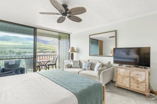 a bedroom with a bed and a flat screen tv at Lahaina Shores #532 in Lahaina