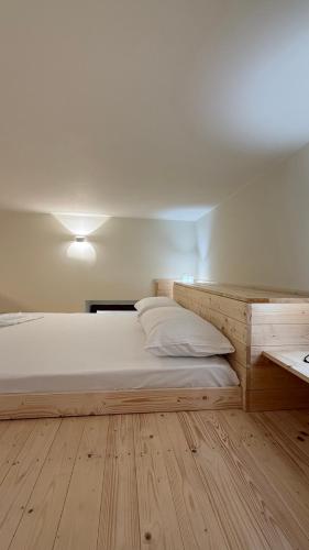 una camera da letto con un grande letto con testiera in legno di Center Duplex a Vlorë