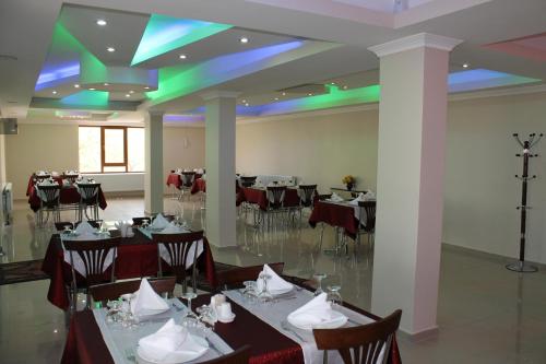 a banquet hall with tables and chairs and green lights at Sultan Pansion Bird Paradise in Ovaciftlik