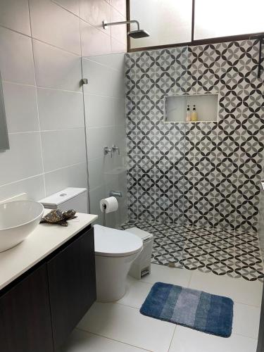 a bathroom with a toilet and a sink and a shower at Casa Colibrí in Alajuela