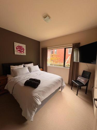 a bedroom with a large white bed and a window at Cardrona Alpine Luxe in Cardrona