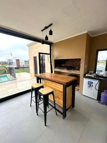 a kitchen with a wooden table and two stools at Glamping privado con pileta y quincho in San Vicente