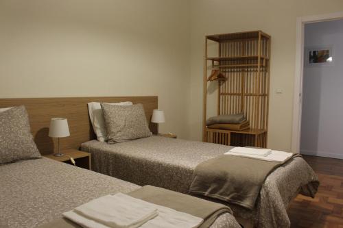 a hotel room with two beds and a shelf at Leiras da Cachada - Gerês in Valdosende