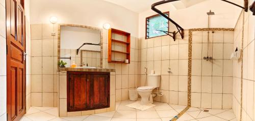 a bathroom with a toilet and a sink and a shower at Kasa First Apartment in Mtwapa