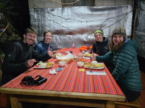 a group of people sitting at a table eating food at Salkantay Wasi in Colcapampa