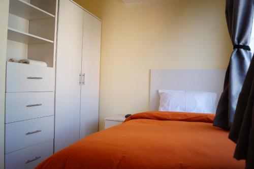 a bedroom with an orange bed and a closet at MV Suites in Monterrey