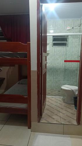 a door to a room with a bed and a toilet at Pousada Taiwan in Ubatuba