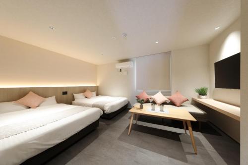 a hotel room with two beds and a table at MOMIJI TERRACE Hiroshima in Hiroshima