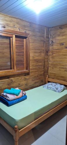 a large bed in a room with wooden walls at Casa de Temporada BR 470 in Cafundó