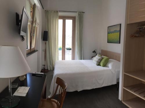 a bedroom with a bed and a desk and a window at La Casa di Andrea Relais in Monterosso al Mare