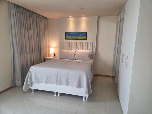 a bedroom with a large bed with a white bedspread at Apartamento Jade Hotel - Park Sul in Brasília