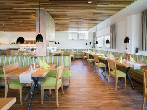 インメンシュタート・アム・ボーデンゼーにあるHotel Gasthaus Kroneのダイニングルーム(木製テーブル、緑の椅子付)