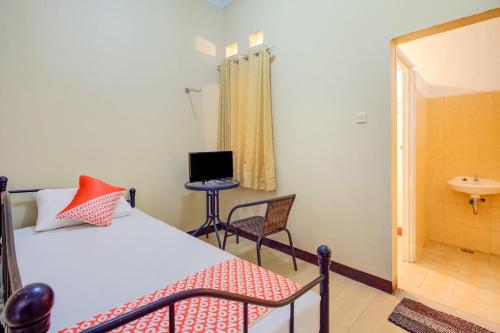a bedroom with a bed and a bathroom with a sink at Hotel O Sofia Homestay Syariah in Bogor