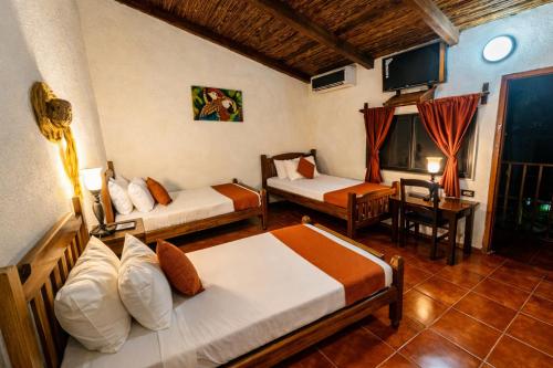 a hotel room with two beds and a television at Hotel El Maltese - Lakefront in Granada