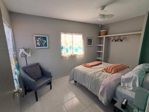 a bedroom with a bed and a chair and a window at Turquesa by the Sea, Elevated Ocean View Retreat in San Carlos