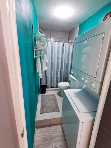 a bathroom with a toilet and a blue wall at Turquesa by the Sea, Elevated Ocean View Retreat in San Carlos