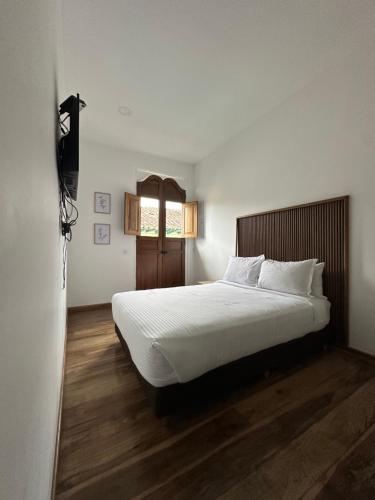 a bedroom with a large white bed and a window at Casa Real Circacia in Circasia