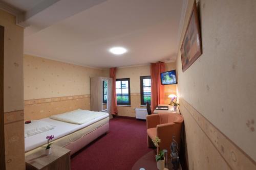 a hotel room with a bed and a desk and window at Hotel Am Rathaus in Menden
