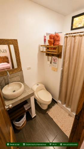 a bathroom with a toilet and a sink and a shower at Casita Madame - Frente al Mar con Desayuno Gourmet in Puerto López