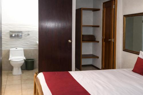 a bedroom with a bed and a toilet in a room at Hotel El Maltese - Lakefront in Granada