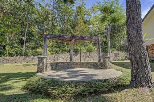 a stone bench sitting next to a tree at Hotel O Villa Inn App Trawas Bintaro Syariah in Kemloko-gede