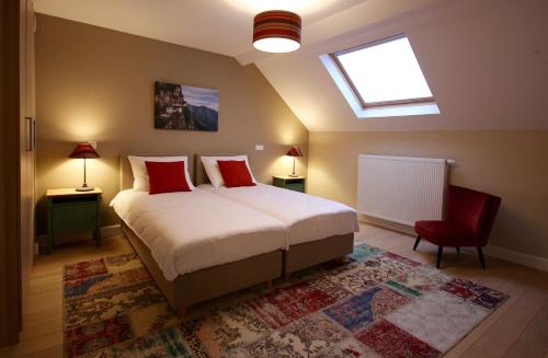 a bedroom with a bed with red pillows and a window at Hooome in Brussels