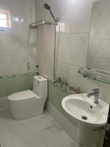 a bathroom with a toilet and a sink at Sơn Tùng House in Quang Ninh