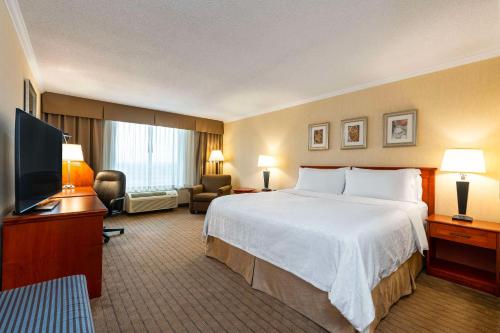 a hotel room with a bed and a flat screen tv at Allure Hotel & Conference Center in Barrie