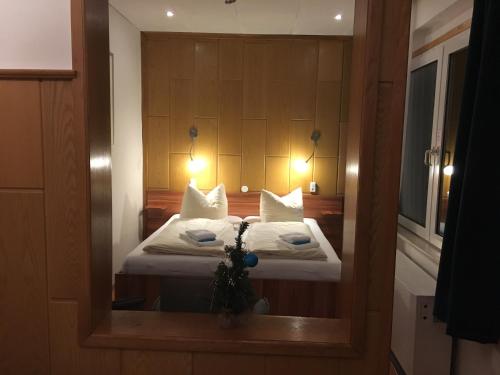 a reflection of a bedroom with a bed in a mirror at Hotel & Restaurant Druidenstein in Trautenstein