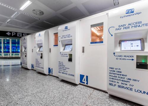 una línea de pago por minuto máquinas en un edificio en Resting Pods - -ZZZleepandGo MXP Airport, en Ferno