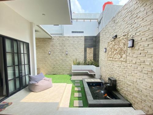 a patio with a koi pond in a brick wall at Moses Homestay, Yogyakarta in Beran-kidul