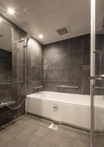 a bathroom with a bath tub and a shower at Tousumi in Fukuoka