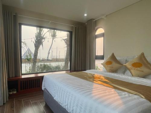 a bedroom with a bed and a large window at Châu Anh House in Ðố Sơn